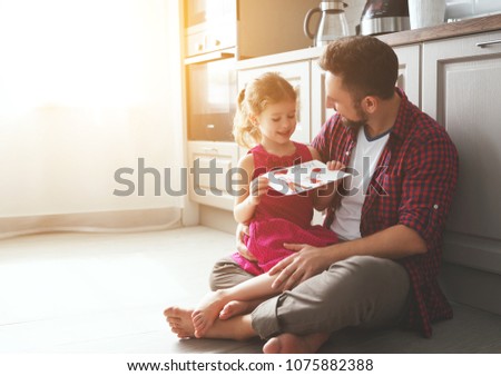 Father's day. Happy family daughter giving dad a greeting card on holiday