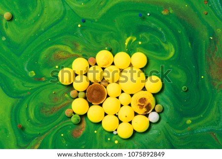 Abstract Colorful drops on oil surface with vibrant colors in background. Color drop in water photographed in motion.