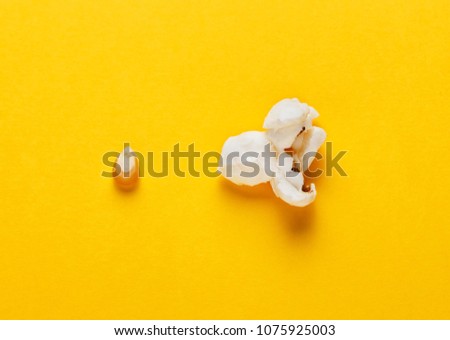 Corn grain and popcorn on yellow background. Concept of evolution and growth. Horizontal image. Top view.