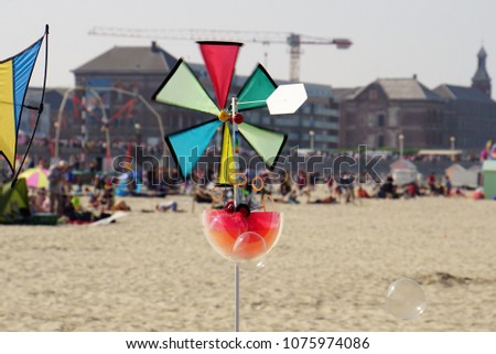 Soap bubbles machine with wind wheel on the sand beach of Normandy. Toys for Kids. Beautiful beach of Berck-sur-Mer. A commune in the Pas-de-Calais department in northern France.