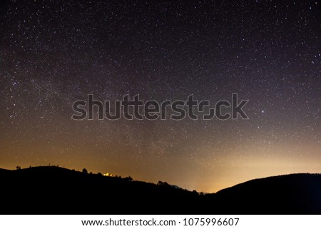 Photo of the starry night sky
with visible mountains on the horizon
