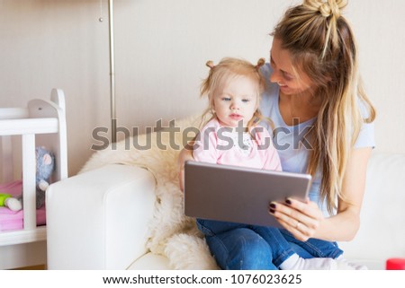 Mom using tablet together with her kid