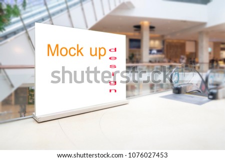 Blank standing sign with copy space for text messege or mock up content in blur department store or shopping mall background.Clipping path include.