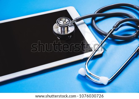 stethoscope with tablet on blue background, health concept