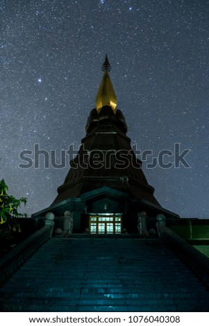 Old Thai Temple at night with stars and the Milky Way shining in the dark sky.