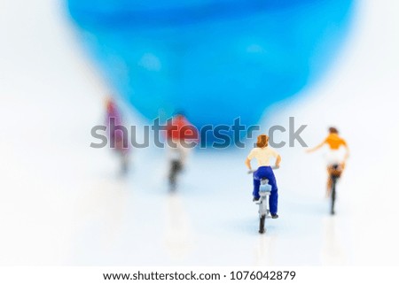 Miniature people : People group riding bicycle with world map. Image use for sport, travel and business concept.