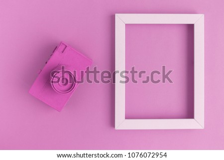 Retro film photo camera colored in pastel pink with photo frame minimal abstract creative concept. Place for photo adding.