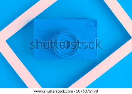 Retro film photo camera colored in blue with photo frame minimal abstract creative concept