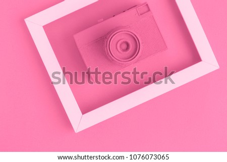 Retro film photo camera colored in pastel pink with photo frame minimal abstract creative concept