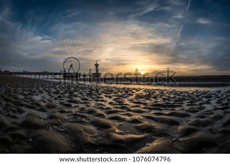 Beautiful sunset at the beach of Scheveningen in the Netherlands with the famous Pier in the background