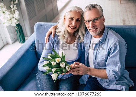 The old man giving flowers to an elderly woman