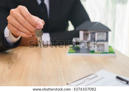 Businessman or sale man giving a house key after sign loan agreement