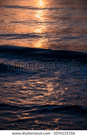 Beautiful sun reflection on the sea with the purple sky. Watching sunrise on the beach moment concept.