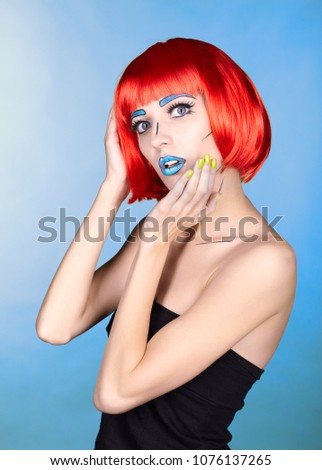 Portrait of young woman in comic  pop art make-up style. Female in red wig on blue background