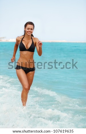 Young attractive woman jogging on the beach