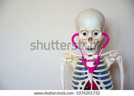 HUMAN SKELETON WITH A STETHOSCOPE ON THE SEW. HEAD AND BODY.