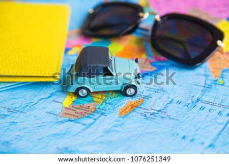 retro car on colorful world map, sunglasses, passport.