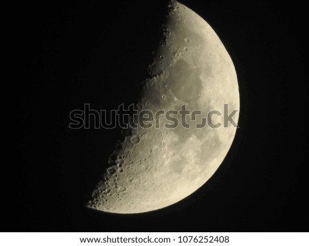 A half moon with visible craters