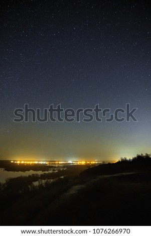 Sky with the stars in the landscape with a pond. Night landscape with a lake.