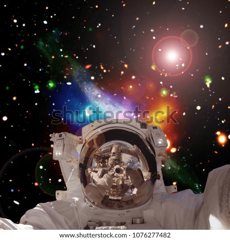 Astronaut posing against galaxies and stars. The elements of this image furnished by NASA.
