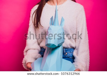 Fashion kid. Designer collection. White big unicorn origami made paper. Girl in beautiful pink dress. Studio shot.