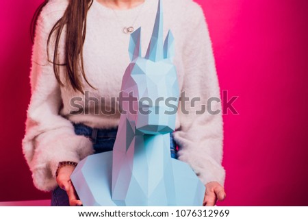 Fashion kid. Designer collection. White big unicorn origami made paper. Girl in beautiful pink dress. Studio shot.