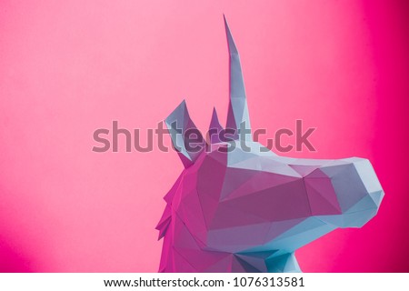 3D paper unicorn on pink background left side, horizontal. Origami toy. Origami pegasus