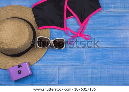 Top view Flat lay, Travel and vacation concept items on blue wooden table. Top view with copy space, summer with camera and Beach accessories
