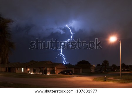 Massive lightning strike very close to homes in a neighborhood Royalty-Free Stock Photo #107631977