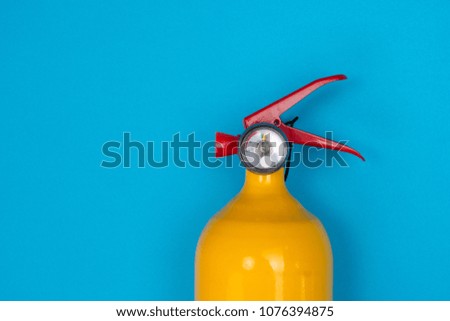 A fire extinguisher resembling a chicken head is placed on a blue background. isolated