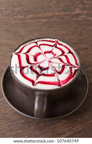 A coffee Latte art   on teak wood table