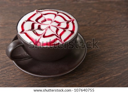 A coffee Latte art   on teak wood table