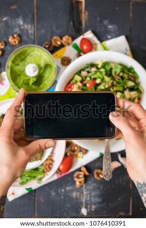 Woman hands take phone photo of food lunch or dinner. Vegetable salad, avocado dip and flatbreads on picnic. Smartphone photography for social networks. Blank screen. Raw vegan vegetarian healthy food