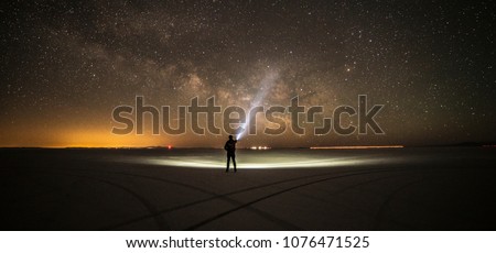 Lighting the milky way with a high lumen flashlight in the middle of Bonneville Salt Flats,Salt Lake City,Utah,USA