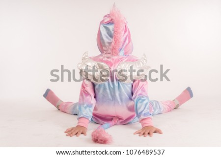 Sweet little kids in unicorn costumes sitting on the floor Isolated on a white background