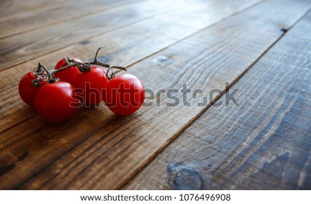 ripe tomatoes on a branch on wooden background