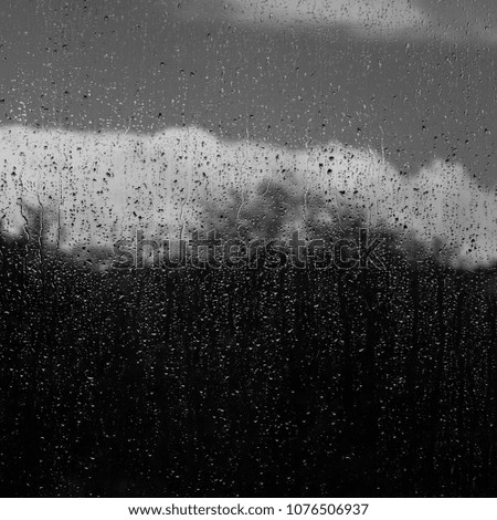 Window with Water Droplets and Cloud in the Background