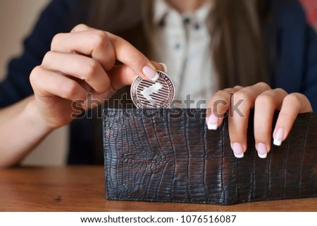 Successfully woman put a litecoin into wallet. LTC Crypto coin saving. Savings money. Blockchain technology. Litecoin cryptocurrency, market platform