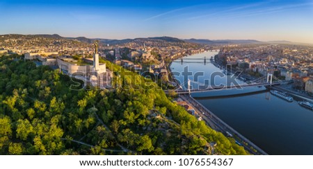 Budapest, Hungary - Aerial panoramic skyline view of Budapest at sunrise. This view includes the Statue of Liberty, Elisabeth Bridge, Buda Castle Royal Palace and Szechenyi Chain Bridge with blue sky Royalty-Free Stock Photo #1076554367