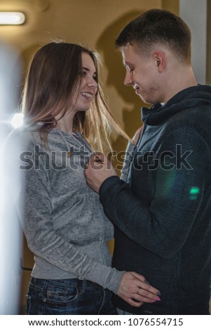 Adult teenagers boyfriend and girlfriend hugging each other in the corridor of an apartment building