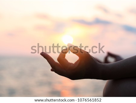 Mantra yoga meditation, spiritual mental health practice with silhouette of woman in lotus pose having peaceful mind relaxation on the beach outdoor training with sunset golden hour heavenly sky Royalty-Free Stock Photo #1076561852