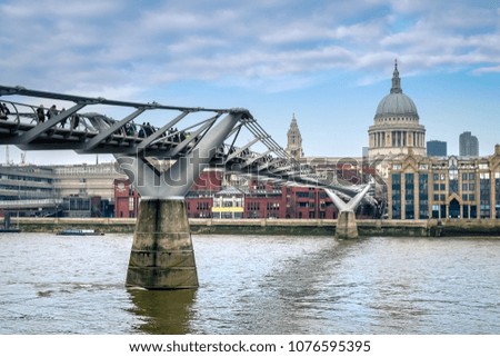 London Millennium Bridge over Thames river with St. Paul Cathedral in the background. 