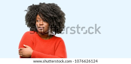 Beautiful african woman confident and happy with a big natural smile laughing, natural expression, blue background