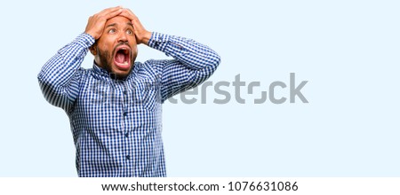 African american man with beard stressful keeping hands on head, terrified in panic, shouting isolated over blue background Royalty-Free Stock Photo #1076631086