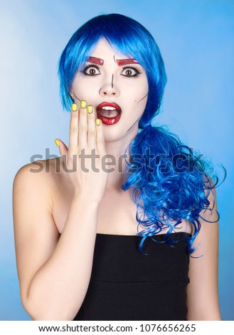 Portrait of young woman in comic  pop art make-up style.  Shoked female in blue wig on blue background.