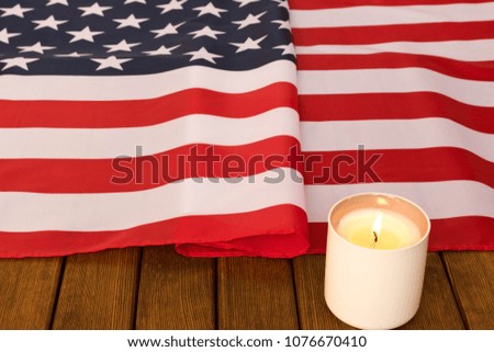 American flag and memorial candle on veterans day . On wooden background  .