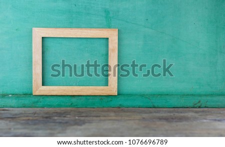 Brown square wooden frame on green background