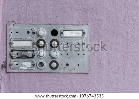 Worn doorbell with intercom on a house wall
