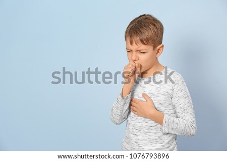 Little boy coughing on light background Royalty-Free Stock Photo #1076793896