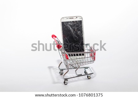 broken white phone display in shopping cart. scattered and broken display on a mobile phone. for repair or for spare parts.